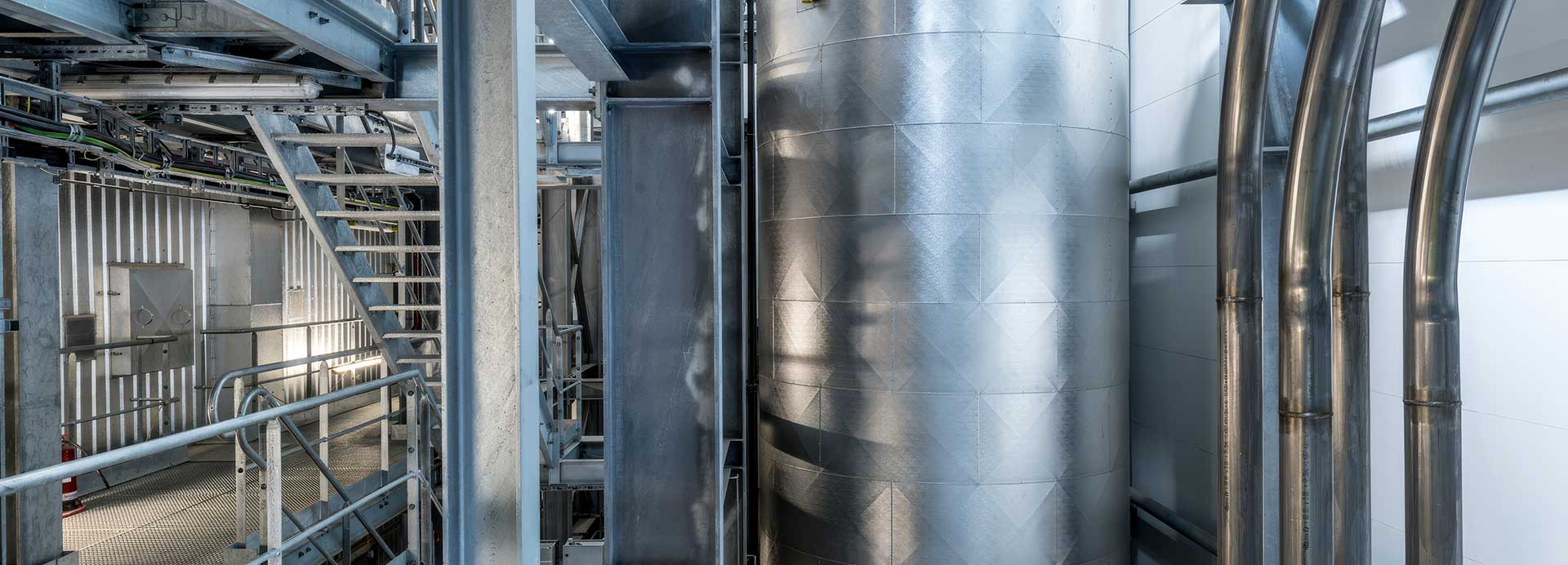 Modernt kontor i loftstil i New York med personal som använder datorer sittande vid rymliga möbler